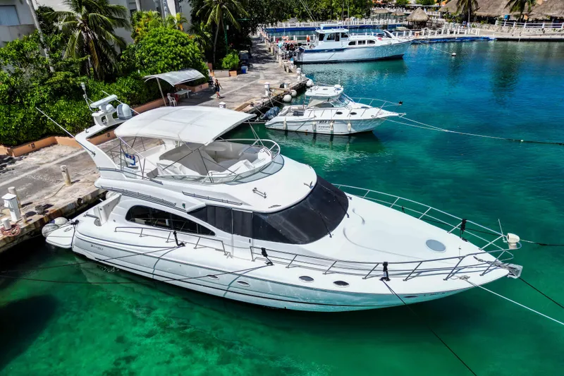 Slide: The Image of 2001 Cruisers Yachts 5000 Sedan Sport docked in clear turquoise water. - 62