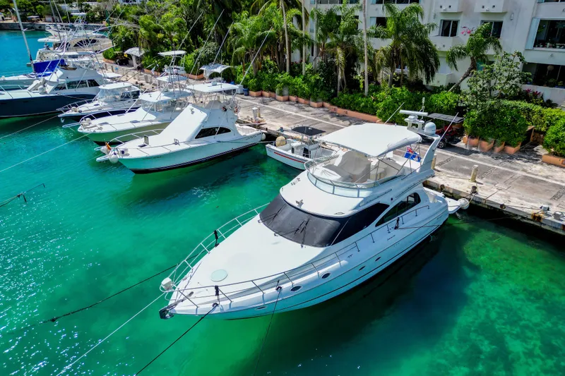 Slide: The Image of 2001 Cruisers Yachts 5000 Sedan Sport docked in clear turquoise water. - 63