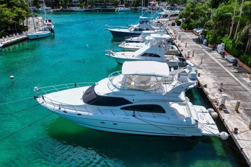 Slide: The Image of 2001 Cruisers Yachts 5000 Sedan Sport docked in a vibrant marina. - 64