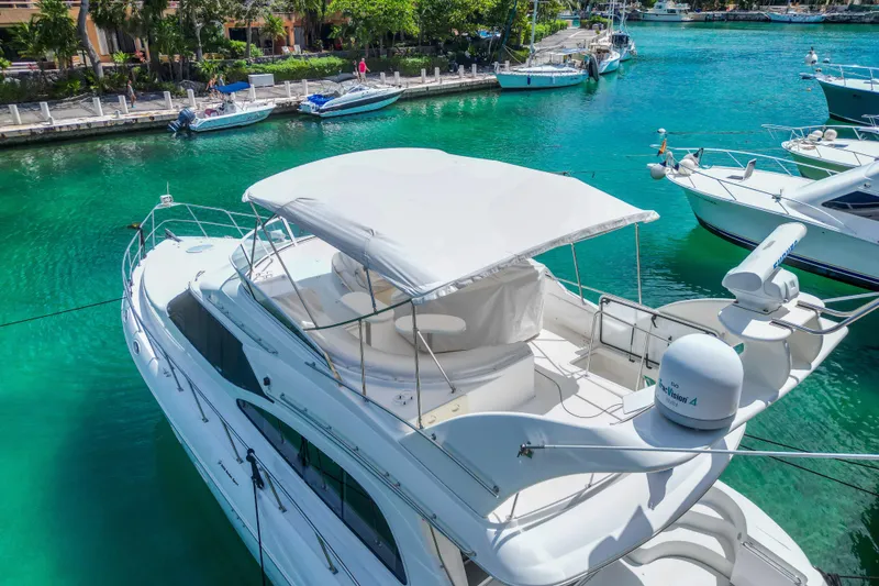 Slide: The Image of 2001 Cruisers Yachts 5000 Sedan Sport docked in clear turquoise water. - 66