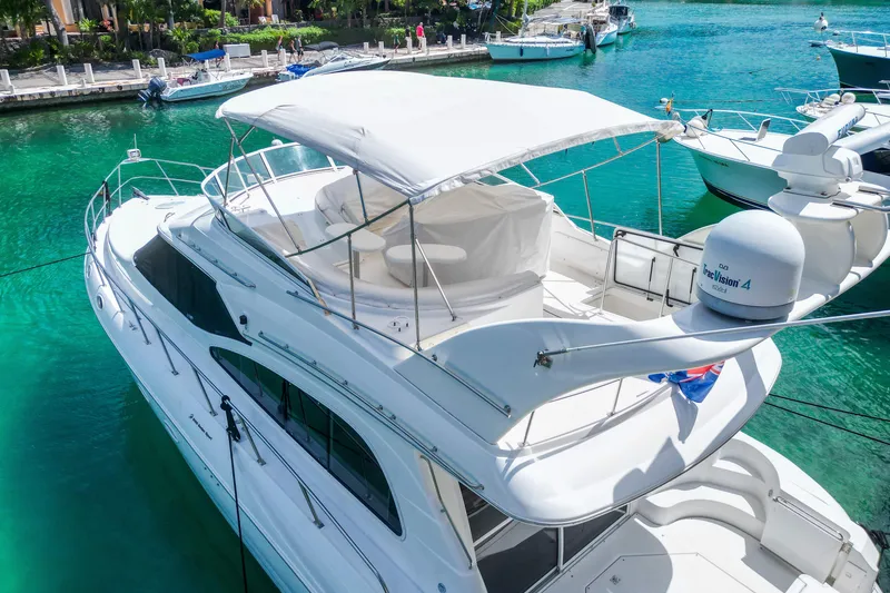 Slide: The Image of 2001 Cruisers Yachts 5000 Sedan Sport docked in clear turquoise water. - 67