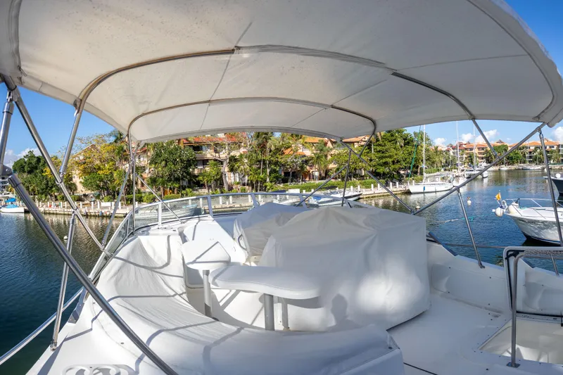 Slide: The Image of 2001 Cruisers Yachts 5000 Sedan Sport, covered deck, docked in a scenic marina. - 71