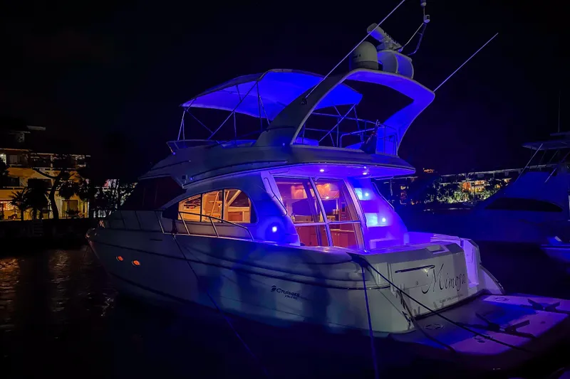 Slide: The Image of 2001 Cruisers Yachts 5000 Sedan Sport illuminated at night with vibrant blue lights. - 72