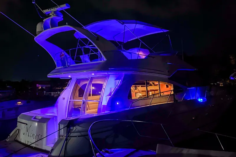 Slide: The Image of 2001 Cruisers Yachts 5000 Sedan Sport illuminated at night with blue lights. - 75