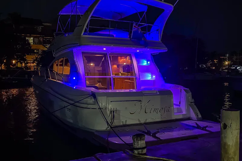 Slide: The Image of 2001 Cruisers Yachts 5000 Sedan Sport illuminated at night with blue lights. - 77