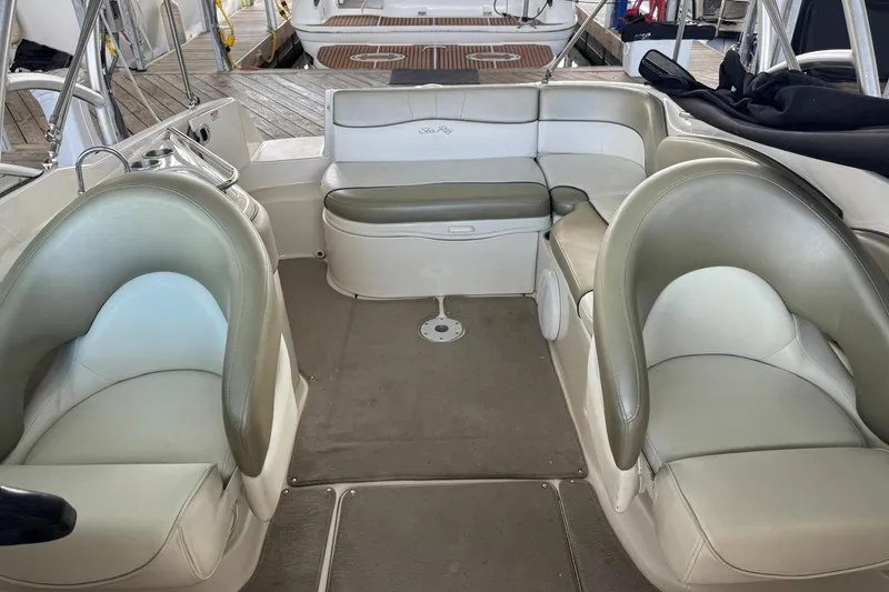 Slide: The Image of Interior of a 2006 Sea Ray 240 Sundeck boat with beige seating and carpet. - 11