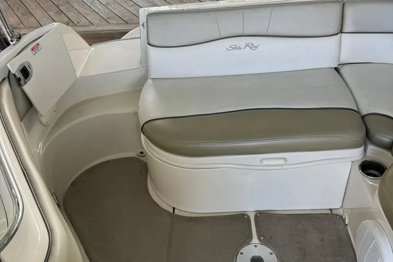 Slide: The Image of 2006 Sea Ray 240 Sundeck interior seating with beige cushions and cup holder. - 12