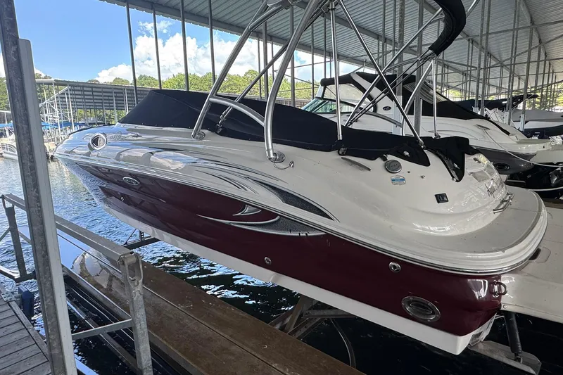 Slide: The Image of 2006 Sea Ray 240 Sundeck boat docked under a covered marina. - 3