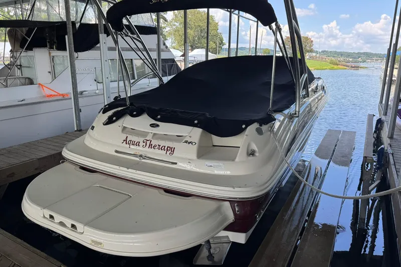 Slide: The Image of 2006 Sea Ray 240 Sundeck boat docked, covered, with "Aqua Therapy" name visible. - 4
