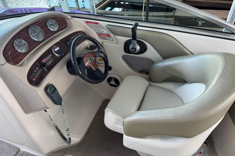 Slide: The Image of 2006 Sea Ray 240 Sundeck helm with gauges, steering wheel, and comfortable seating. - 7