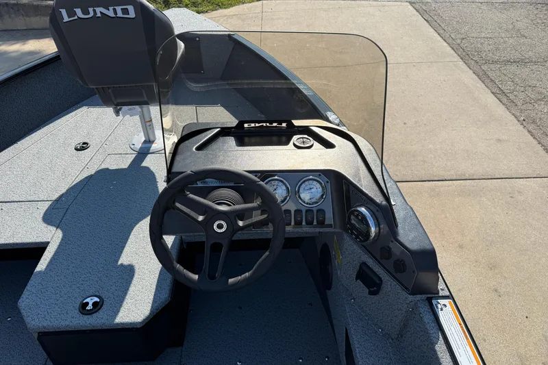 Slide: The Image of 2026 Lund 1675 Adventure SS boat dashboard with steering wheel and gauges. - 19