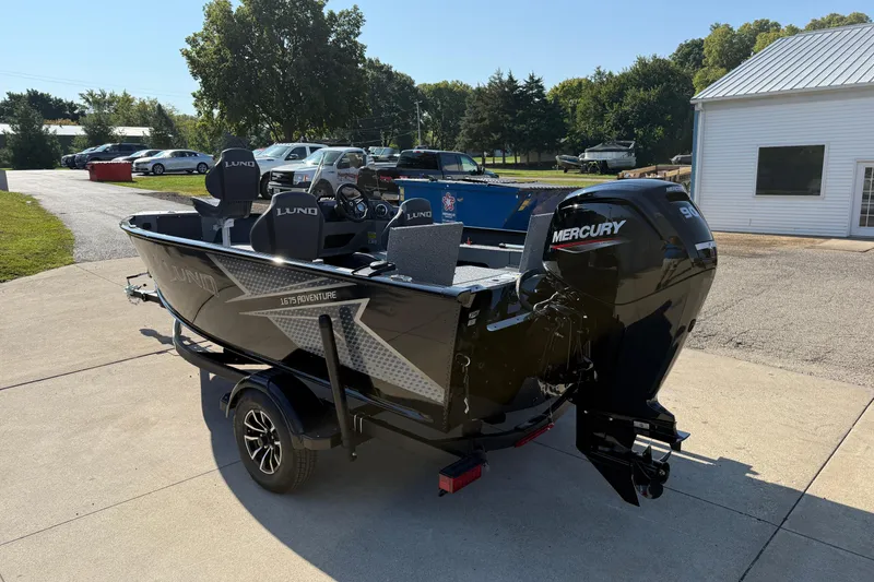 Slide: The Image of 2026 Lund 1675 Adventure SS boat with Mercury engine, parked outdoors on a sunny day. - 6