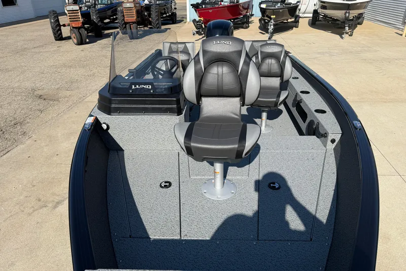 Slide: The Image of 2026 Lund 1675 Adventure SS boat with dual seats and console, parked outdoors. - 9