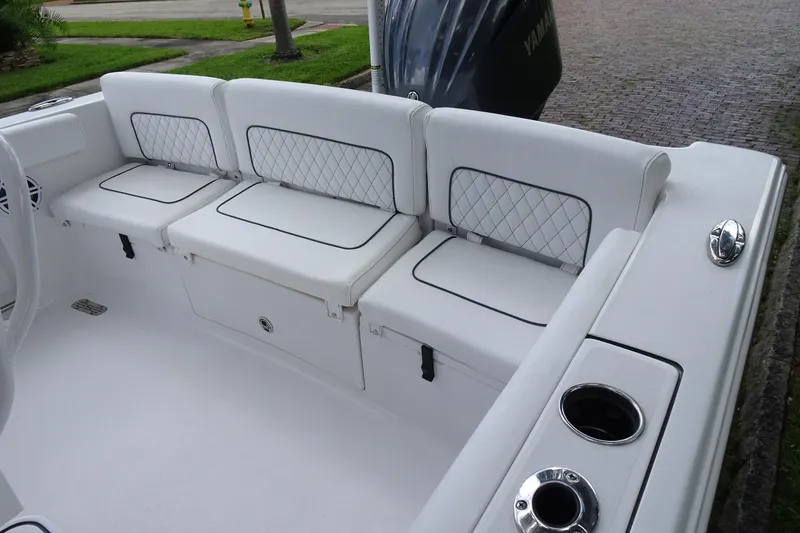 Slide: The Image of 2023 Sportsman Heritage 231 Center Console boat with white cushioned seating and cup holders. - 10