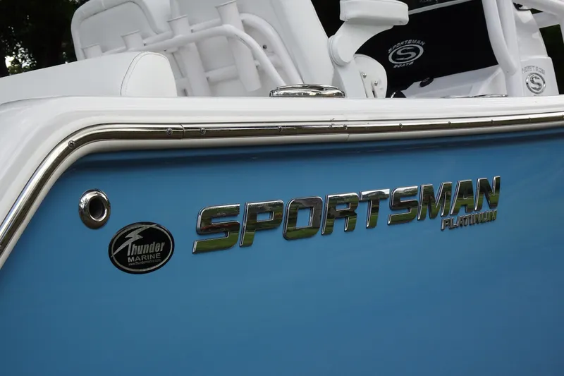 Slide: The Image of 2023 Sportsman Heritage 231 Center Console boat with blue exterior and chrome logo detailing. - 19