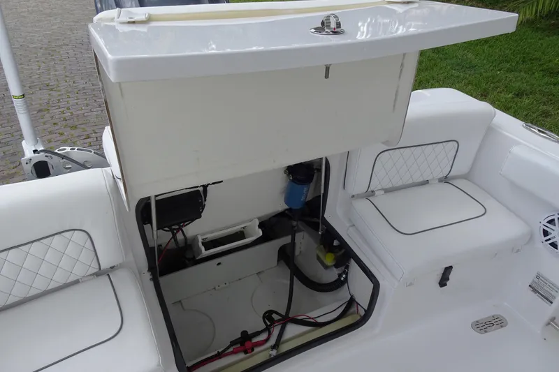 Slide: The Image of 2023 Sportsman Heritage 231 Center Console boat storage compartment open, revealing interior components. - 4