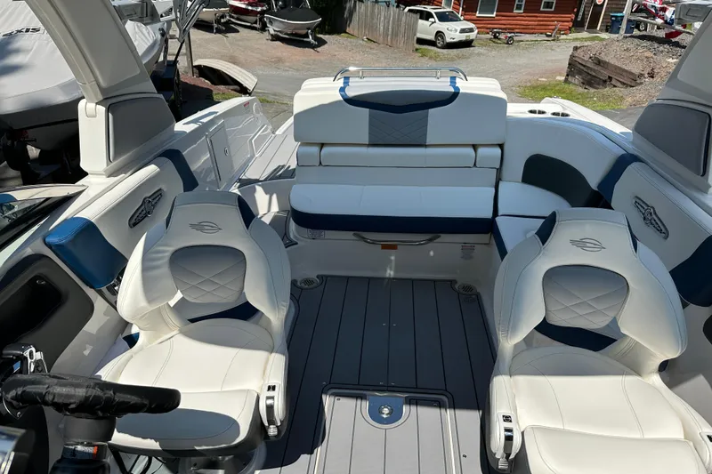 Slide: The Image of 2024 Chaparral 26 Surf boat interior with white and blue seating, modern design. - 10