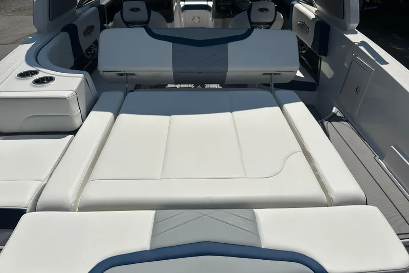 Slide: The Image of 2024 Chaparral 26 Surf boat interior with luxurious white seating and cup holders. - 11