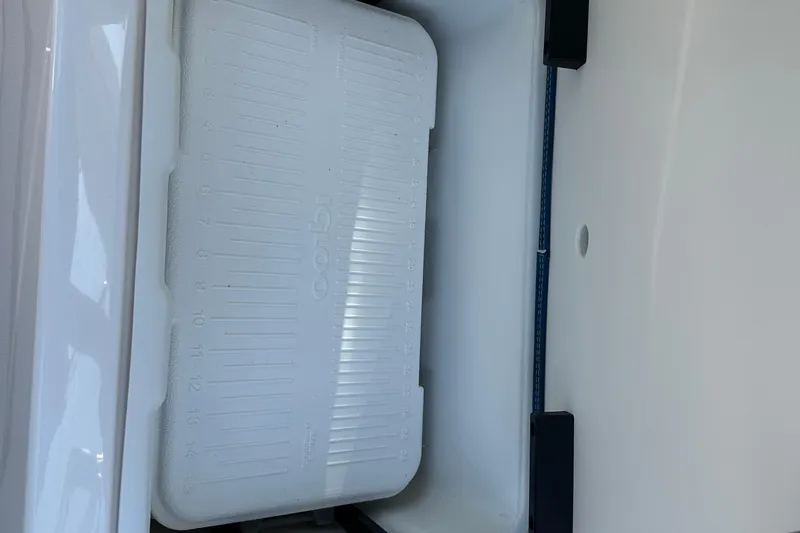 Slide: The Image of 2024 Chaparral 26 Surf boat storage compartment with Igloo cooler. - 16