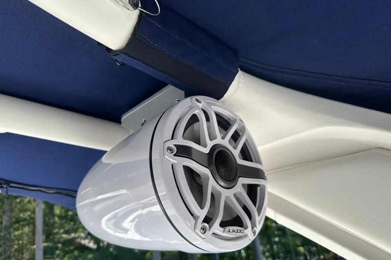 Slide: The Image of 2024 Chaparral 26 Surf boat with JL Audio speaker under blue canopy. - 18