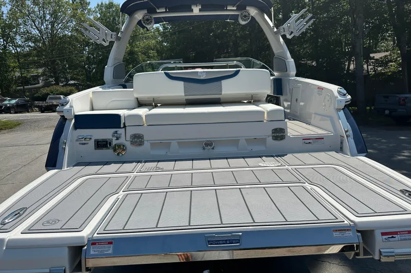 Slide: The Image of 2024 Chaparral 26 Surf boat with spacious deck and seating, docked outdoors. - 20