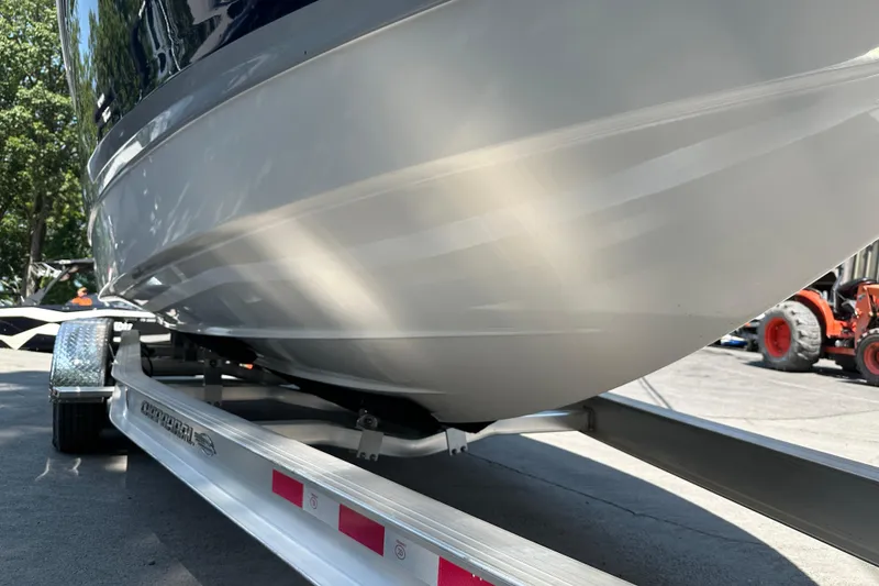 Slide: The Image of 2024 Chaparral 26 Surf boat on trailer, close-up view of hull and trailer details. - 24