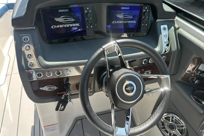 Slide: The Image of 2024 Chaparral 26 Surf boat dashboard with steering wheel and dual Simrad displays. - 5