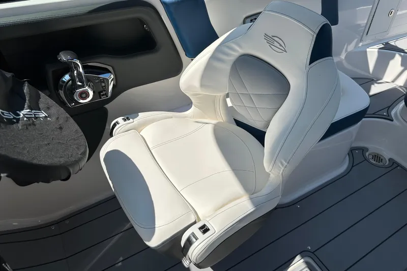 Slide: The Image of 2024 Chaparral 26 Surf boat interior with white captain's chair and control panel. - 6