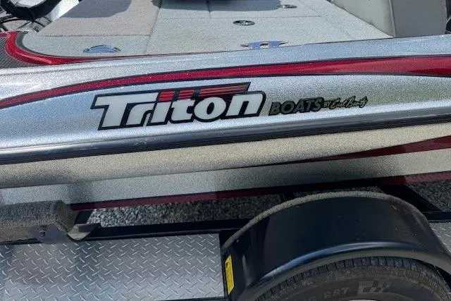 Slide: The Image of 2005 Triton Tr-186 DC boat on trailer, featuring sleek design and logo. - 2
