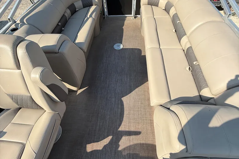 Slide: The Image of 2021 Sun Tracker Party Barge 22 DLX interior with beige seating and spacious layout. - 10