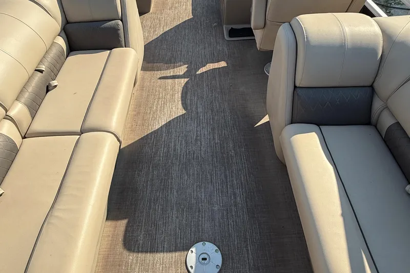 Slide: The Image of 2021 Sun Tracker Party Barge 22 DLX interior with beige seating and spacious layout. - 12