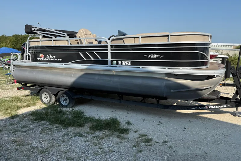 Slide: The Image of 2021 Sun Tracker Party Barge 22 DLX pontoon boat on trailer, parked outdoors. - 4
