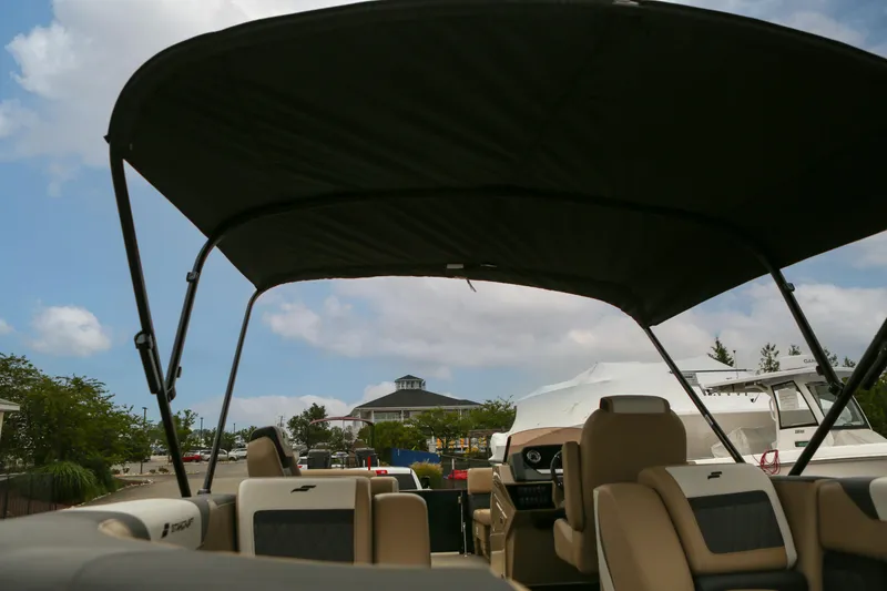 Slide: The Image of 2026 Starcraft SLS 3 boat interior with canopy, parked outdoors under a blue sky. - 26