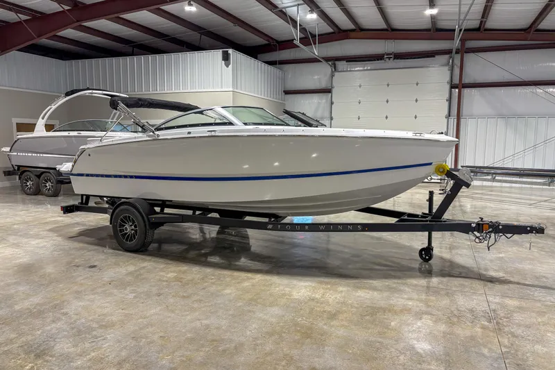 The Image of 2026 Four Winns H1 boat on trailer in indoor storage facility. - 1
