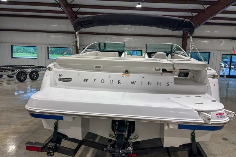 Slide: The Image of 2026 Four Winns H1 boat in showroom, rear view with branding visible. - 7
