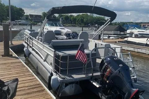 Slide: The Image of 2020 Sweetwater 2286 SFL pontoon boat docked, featuring a canopy and outboard motor. - 3