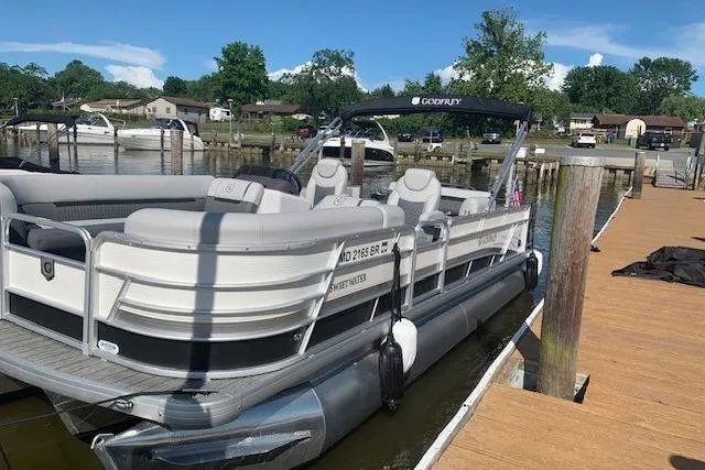 Slide: The Image of 2020 Sweetwater 2286 SFL pontoon boat docked at a marina. - 4