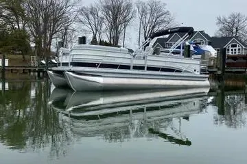 Slide: The Image of 2020 Sweetwater 2286 SFL pontoon boat on calm water near lakeside homes. - 7