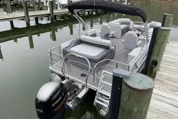 Slide: The Image of 2020 Sweetwater 2286 SFL pontoon boat docked, featuring spacious seating and a powerful outboard motor. - 8