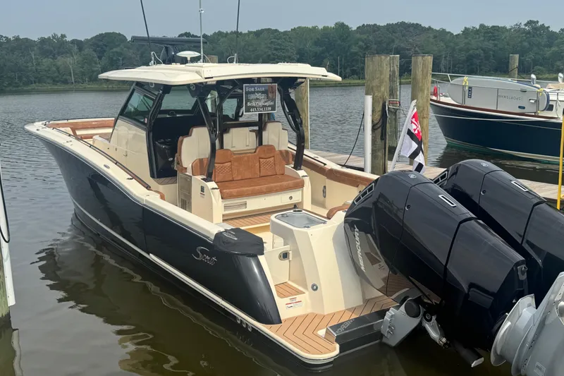 Slide: The Image of 2023 Scout 400 LXF boat docked, featuring luxurious seating and powerful outboard engines. - 1