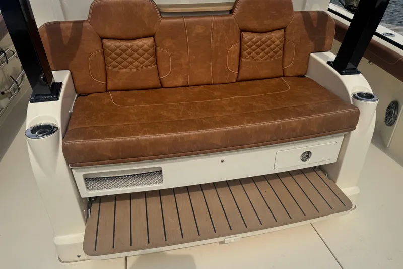 Slide: The Image of Luxurious brown leather seating on 2023 Scout 400 LXF boat, featuring cup holders and storage. - 10