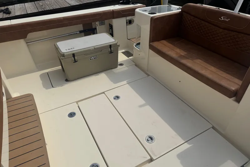 Slide: The Image of 2023 Scout 400 LXF boat interior with brown seating and Yeti cooler. - 11