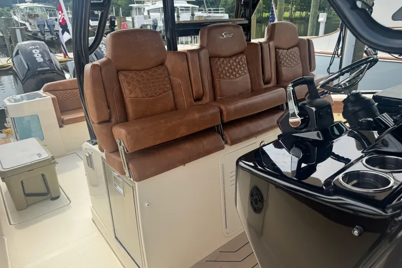 Slide: The Image of 2023 Scout 400 LXF boat interior with luxurious brown leather seating and sleek control panel. - 12