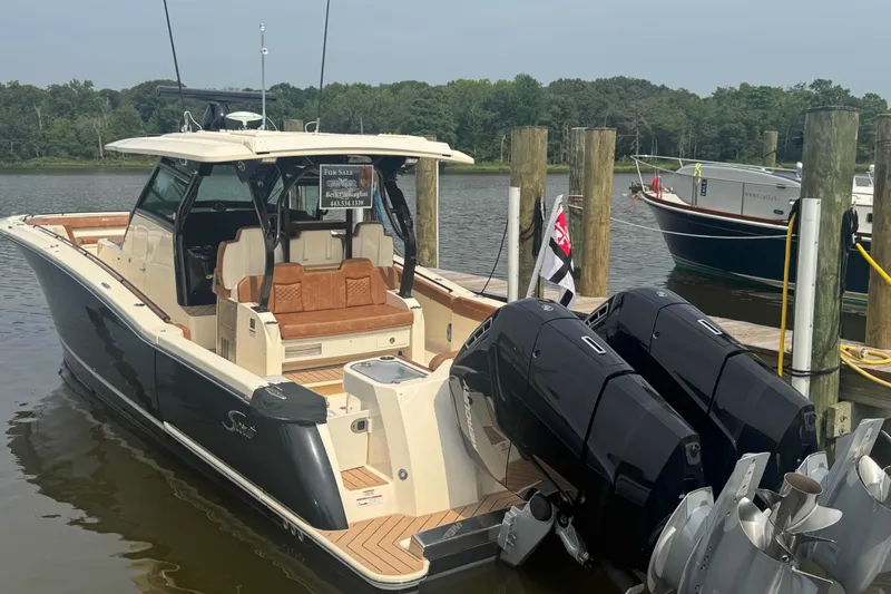 Slide: The Image of 2023 Scout 400 LXF boat docked, featuring dual outboard engines and luxurious seating. - 2