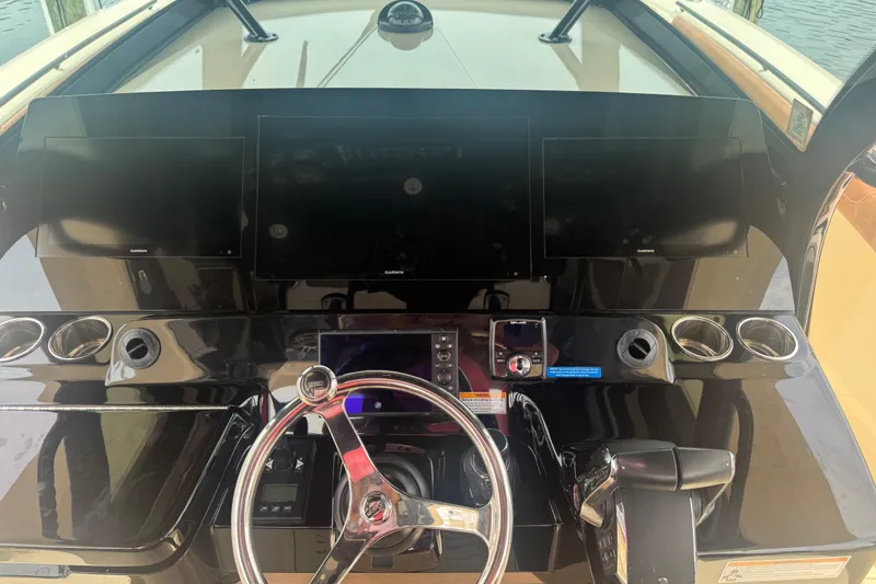 Slide: The Image of 2023 Scout 400 LXF boat dashboard with multiple Garmin screens and steering wheel. - 21