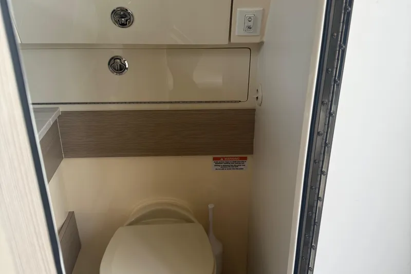 Slide: The Image of 2023 Scout 400 LXF boat interior bathroom with toilet and storage compartments. - 31