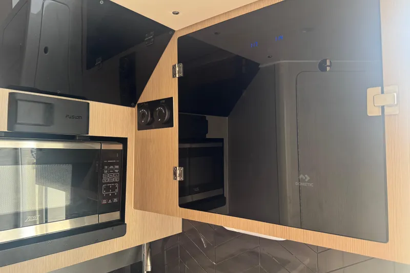 Slide: The Image of Modern kitchen area in 2023 Scout 400 LXF boat with microwave and storage cabinets. - 35