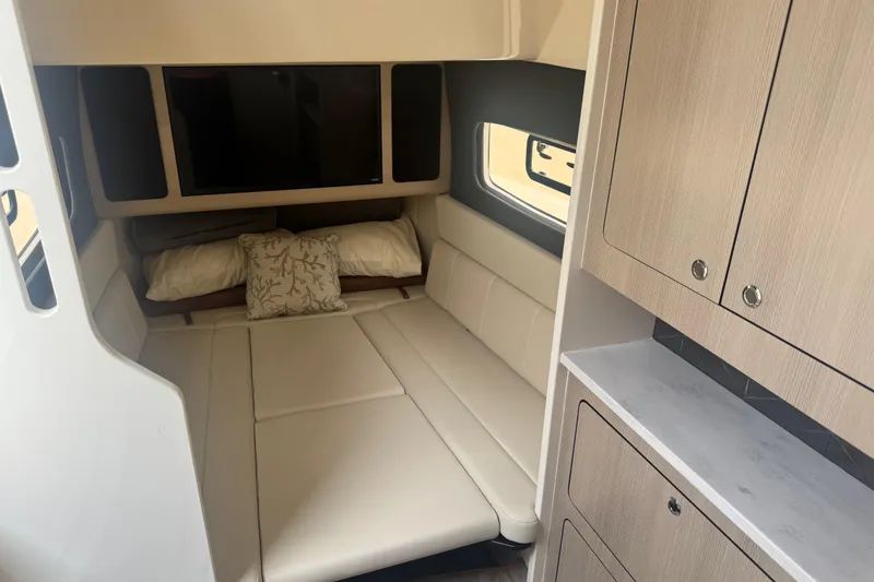 Slide: The Image of 2023 Scout 400 LXF cabin interior with bed, TV, and storage cabinets. - 46