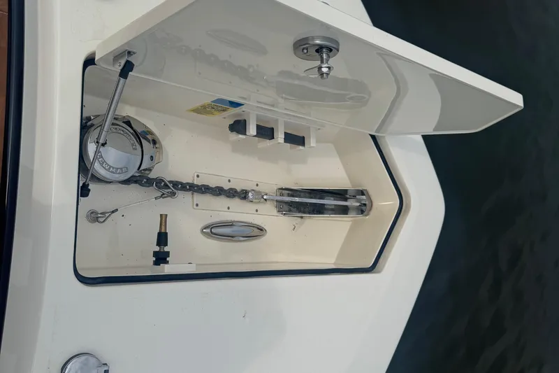 Slide: The Image of Anchor compartment of 2023 Scout 400 LXF boat, featuring chain and winch system. - 50