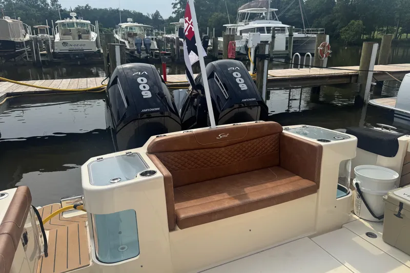 Slide: The Image of 2023 Scout 400 LXF boat with twin Mercury 600 engines docked at marina. - 8